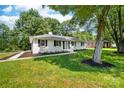 Charming single story home with a well manicured lawn, black shutters, and mature trees overhead at 104 Spargo St, Gastonia, NC 28056