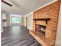 Open-concept living area showcasing a brick fireplace and hardwood floors at 125 Circle Dr, Mount Holly, NC 28120