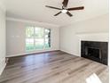 Bright living room featuring hardwood floors, a fireplace, and a large window with a view of the outdoors at 14739 Cane Field Dr, Charlotte, NC 28273