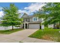 Inviting two-story home with a covered front porch, a two-car garage, and lush greenery at 236 Robinwood Ln, Clover, SC 29710