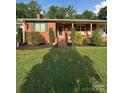 Quaint brick home with manicured landscaping and a cozy covered porch at 3085 Faith Rd, Salisbury, NC 28146