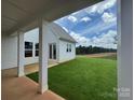 Beautiful lawn and patio featuring white columns, white siding, and an expansive lawn with mature trees at 4528 Splash Trl # 195, Sherrills Ford, NC 28673