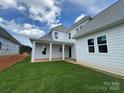 A beautifully landscaped backyard featuring a covered patio with white columns on a sunny day at 4528 Splash Trl # 195, Sherrills Ford, NC 28673