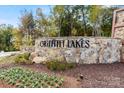 Stone monument sign at Griffith Lakes with flower beds and landscaping against the backdrop of fall foliage at 5337 Mint Harbor Way # 0302, Charlotte, NC 28269