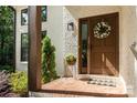 Close-up view of a welcoming front door with brick entryway, adorned with a wreath and potted plants at 6639 Camp Creek Rd, Lancaster, SC 29720