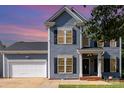 Charming two-story home with blue siding, black shutters, and well-maintained landscaping at 6930 Culloden More Ct, Charlotte, NC 28217