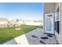 Large backyard featuring lush green grass and pea gravel path leading to back door at 8351 Rolling Meadows Ln, Huntersville, NC 28078