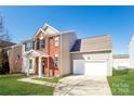 Attractive home with brick facade, vinyl siding, attached garage and well-maintained lawn at 8351 Rolling Meadows Ln, Huntersville, NC 28078