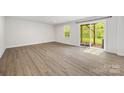 Bright living room with wood flooring, sliding glass door with backyard views, and neutral walls at 2040 Dornoch Rd, Tega Cay, SC 29708