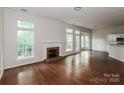 Open-concept living room with hardwood floors, a fireplace, and access to the kitchen area at 3422 Balsam Tree Dr, Charlotte, NC 28269