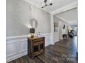 Inviting entryway with hardwood floors, decorative table, accent mirror, and elegant wainscoting at 537 Lincoln Quarters Ln, Fort Mill, SC 29708