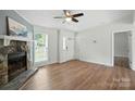 Bright living room boasts hardwood floors, a stone fireplace, and backyard views at 8106 Strawberry Point Dr, Charlotte, NC 28215