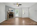 Open living room featuring a stone fireplace, ceiling fan, and hardwood floors at 8106 Strawberry Point Dr, Charlotte, NC 28215
