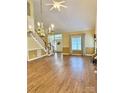 Bright living room with hardwood floors, a fireplace, and grand staircase with large windows at 105 Whimbrel Ln, Mooresville, NC 28117