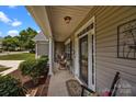 Charming front porch with seating area, decorative rug and attractive landscaping at 191 Harris Farm Rd, Mooresville, NC 28115