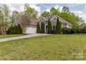 Brick home featuring attached two-car garage, driveway and manicured lawn at 233 Highland Forest Dr, Clover, SC 29710