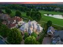 Breathtaking aerial view of a luxurious home backing onto a golf course with a serene pond at 300 Eagle Bend Dr, Waxhaw, NC 28173