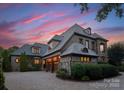 A stunning home with stone and brick accents, complemented by a paved driveway and lush landscaping at twilight at 300 Eagle Bend Dr, Waxhaw, NC 28173