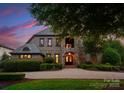 Inviting front exterior with stone accents, professional landscaping, and a grand entrance at dusk at 300 Eagle Bend Dr, Waxhaw, NC 28173