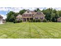Charming two-story brick home boasting a lush green lawn, mature trees, and classic architectural details at 3113 Beaver Dam Dr # 37, Monroe, NC 28110