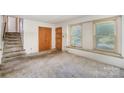 Bright living room featuring neutral walls, staircase and natural light from large windows at 421 Vickery Dr, Charlotte, NC 28215