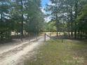View of a dirt road leading to a fenced property at 8221 Feather Run Rd, Kershaw, SC 29067