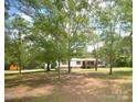 A view of the house surrounded by trees. A large yard at 8221 Feather Run Rd, Kershaw, SC 29067