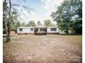 Charming ranch home featuring a welcoming front porch and mature trees at 8221 Feather Run Rd, Kershaw, SC 29067