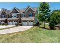 Lovely view of a townhome featuring a lawn, landscaping, and two-car garage at 113 Burlingame Ct, Mooresville, NC 28117