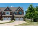 Gorgeous brick townhome featuring attached garages, manicured landscaping, and driveway at 113 Burlingame Ct, Mooresville, NC 28117
