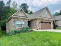 Charming single-story home featuring a stone facade, well-manicured lawn and colorful flower beds at 194 T R Harris Dr, Shelby, NC 28150