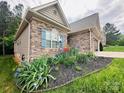 Landscaped front yard with colorful flower beds framing the stone facade of the single-story home at 194 T R Harris Dr, Shelby, NC 28150