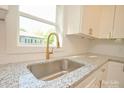 New kitchen features a deep stainless sink, a gooseneck faucet, and speckled granite countertops at 307 N Catawba St, Lancaster, SC 29720