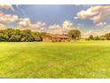 Charming brick home featuring a well-manicured lawn and mature trees against a blue sky at 404 Baxter Rd, Cherryville, NC 28021