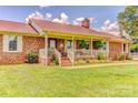 Inviting brick home with a charming front porch and landscaped flower beds at 404 Baxter Rd, Cherryville, NC 28021