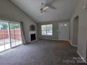 Cozy living room featuring a fireplace, vaulted ceiling, and natural light from a sliding glass door at 3320 Hunting Wood Ct, Gastonia, NC 28052