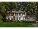 Charming two-story home with a manicured lawn, lush landscaping, and mature trees at 601 Highland Forest Dr, Charlotte, NC 28270