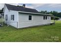 A side view of this cozy home that features light-colored siding and a spacious, green lawn at 104 Franklin St, Clover, SC 29710