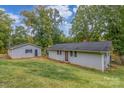 Cozy one-story home with a detached garage, green lawn, and private lot at 7101 Signer Rd, Charlotte, NC 28278