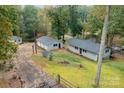 Property showcasing a detached garage, home, and a large driveway with lush green lawn at 7101 Signer Rd, Charlotte, NC 28278