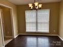 Inviting dining area featuring a large window, wood floors, and modern lighting at 2113 Ballingarry Dr, Statesville, NC 28625