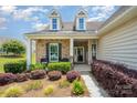 Charming front porch with decorative columns and lush landscaping creates an inviting entrance to this home at 7015 Gracefield Ln, Fort Mill, SC 29707