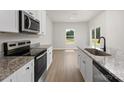 Modern kitchen with stainless steel appliances, granite countertops, and white cabinets at 7019 Jerimoth Dr, Charlotte, NC 28215
