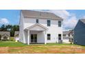 The rear of this two-story home features a covered patio and a spacious backyard at 7023 Jerimoth Dr, Charlotte, NC 28215