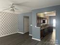 Open-concept living space with stylish wallpaper, updated flooring, and seamless access to the kitchen at 7125 Flying Scotsman Dr, Charlotte, NC 28213