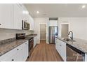 Modern kitchen featuring white cabinetry, granite countertops, stainless steel appliances and hardwood floors at 7315 Jerimoth Dr, Charlotte, NC 28215