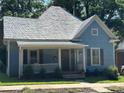 Charming light blue house featuring a inviting front porch with white trim, adding to its curb appeal at 115 E Steele St, Salisbury, NC 28144
