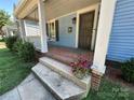 Inviting front porch with classic brick flooring and swing, adding warmth to the home's exterior at 115 E Steele St, Salisbury, NC 28144
