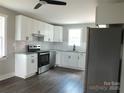 Well-lit kitchen featuring white cabinets, stainless appliances, and granite counters at 1732 Rocky River Rd, Lancaster, SC 29720