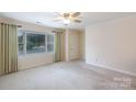 Bright bedroom featuring a large window, neutral carpet, and a ceiling fan at 238 Pointe Cir, Rock Hill, SC 29732